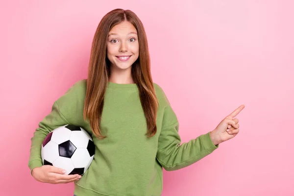 明るい甘い女の子の写真は緑色のトレーナーを身に着けていますサッカーポインティング空のスペース隔離されたピンク色の背景 — ストック写真