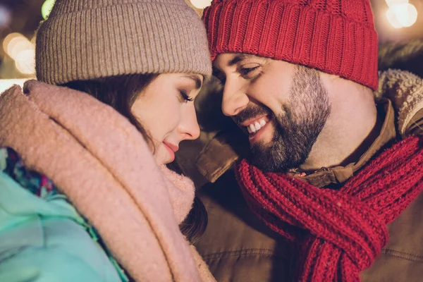 Cropped photo of romantic young couple hug wear cap jacket scarf on christmas outside outdoors.