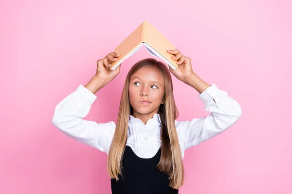 Foto Von Unsicheren Schulkind Halten Lehrbuch Über Dem Kopf Versuchen — Stockfoto
