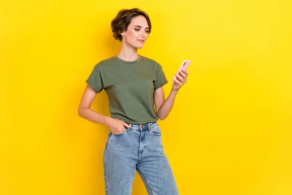 素敵な正の女性の肖像ボブヘアドレスカーキTシャツ手でポケット読みますソーシャルメディア孤立した上の黄色の色の背景 — ストック写真