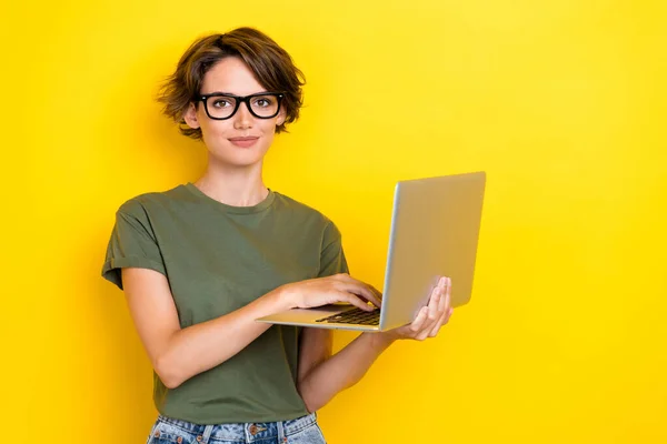 ボブの髪型とスマートインテリジェントな女の子の写真は 黄色の色の背景に隔離されたカーキ色のTシャツを保持ノートパソコンの書き込み電子メール — ストック写真