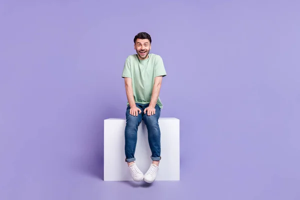 Ganzkörperfoto Von Attraktiven Jungen Mann Sitzt Weiß Podium Schüchtern Aufgeregt — Stockfoto