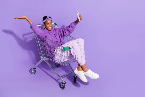 フルサイズ写真の正レズビアンバイセクシャル女性座ってショッピングカード作る自画撮りビデオVlog絶縁上の紫色の背景 — ストック写真
