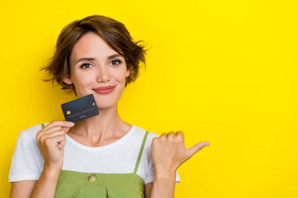 迷人的女商人拿着新的黑色塑料回收银行卡指模照片 用黄色背景将产品隔离起来 — 图库照片