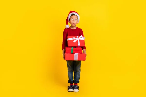 かわいい男の子のフルサイズの写真感銘を受けた多くのクリスマスプレゼント北極は黄色の色の背景に隔離された流行の赤い外観を身に着けている — ストック写真
