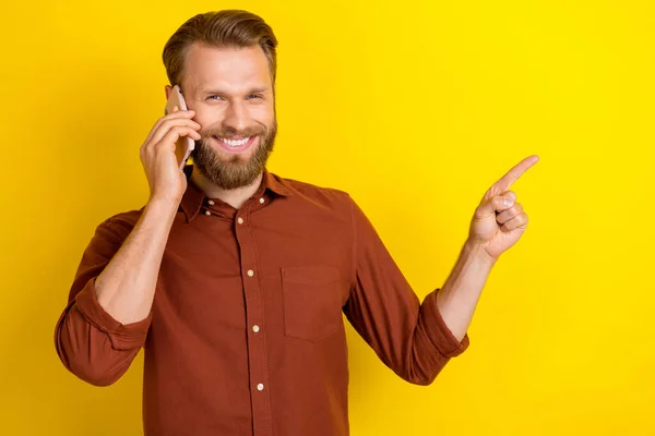 stock image Photo of attractive stylish gentleman speak telephone arm direct empty space recommend device shop isolated on yellow color background.