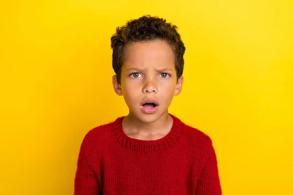 魅力的な小さな生徒の男の子の写真の肖像画は混乱口を開いて見える黄色の色の背景に隔離された流行の赤いニットウェアの服を着用 — ストック写真