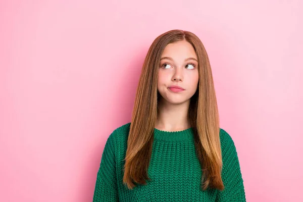 可爱女学生的照片肖像看上去有些怀疑 不确定空旷的空间 穿着时髦的绿色针织服装 背景是粉红色的 — 图库照片