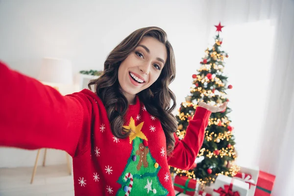 若いです女の子取りますショットホールドパームデモンストレーション彼女の快適な家のアパートクリスマスツリーで装飾が室内に滞在 — ストック写真