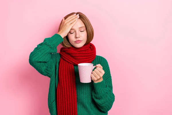 Photo of unhappy upset young lady wear green sweater red scarf feeling bad drinking hot medicine isolated pink color background.