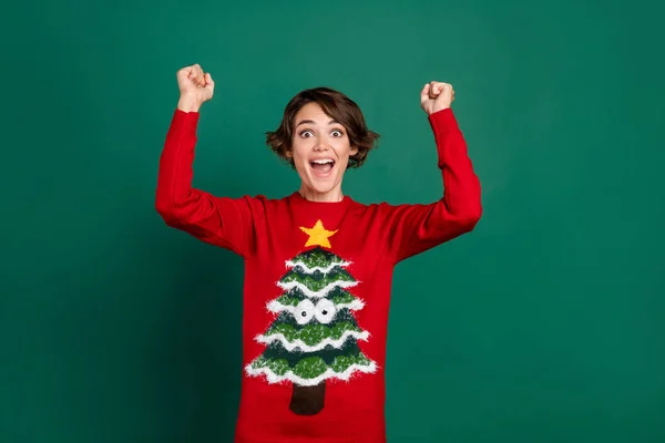 Photo of astonished joyful lady trendy ugly outfit raise hand rejoice december shopping sale empty space isolated on green color background.