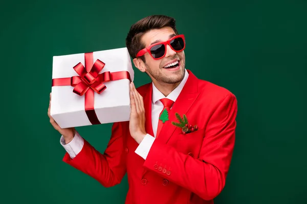 Portrait of cheerful excited person hold desirable giftbox toothy smile isolated on green color background.