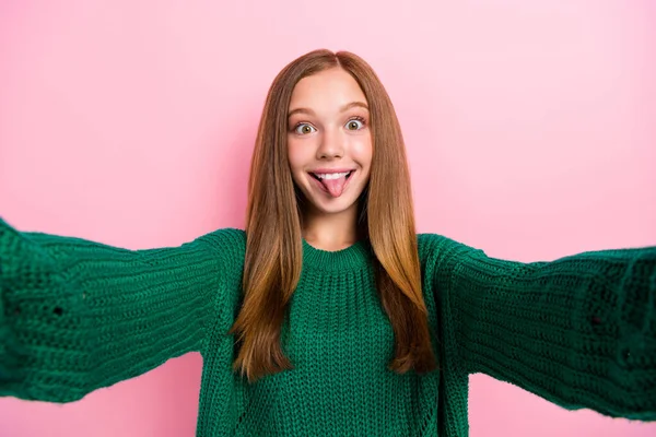 可爱时髦的年轻女士身穿绿色毛衣 自拍自拍的照片 显示舌头孤立的粉色背景 — 图库照片
