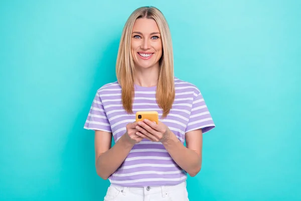 チャーミングな可愛いビジネス女性の写真縞模様の紫のTシャツを着てシアン色の背景に隔離された新しいアップルのIphoneの広告を保持 — ストック写真