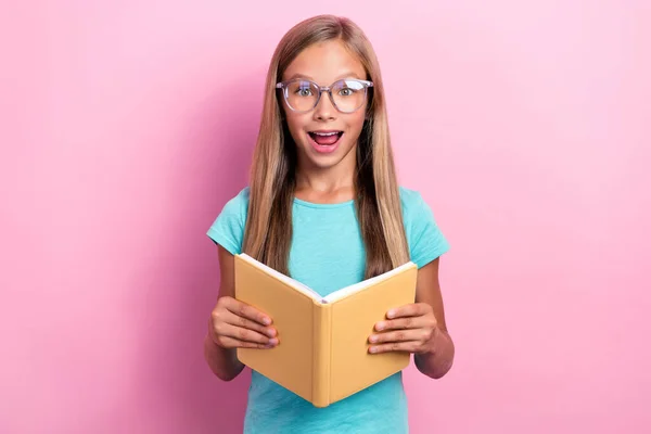 賢い興奮した小さな子供の写真は ターコイズTシャツの眼鏡をかけて読むプランナー孤立ピンク色の背景 — ストック写真