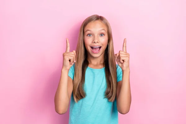 ファンキーなクレイジー正の子供の女の子の写真は ピンクの色の背景に隔離された製品を実証する提供を指しているサイアンTシャツの指を着用 — ストック写真