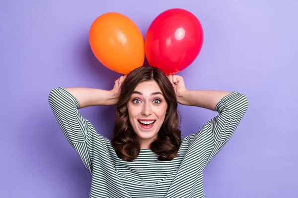 漂亮可爱的积极女士拿着两个气球的近照让耳朵在新年嘉年华公司被紫色背景隔离 — 图库照片