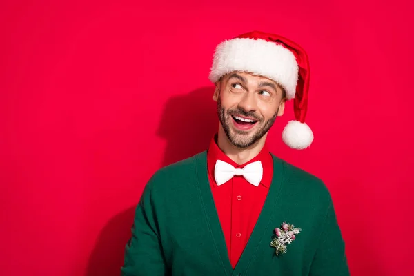 stock image Closeup photo of young hadsome stubble beard man wear santa headwear look dreamy empty space advertisement new brand isolated on red color background.