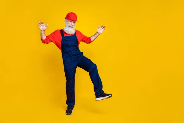喜びに満ちた正引退したビルダーのフルサイズの写真長い髭の赤いヘッドギアは黄色の色の背景に隔離された空のスペースダンスに見えます — ストック写真