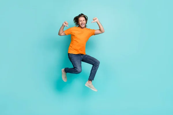 멋지고 남자가 주황색 티셔츠를 점프하는 장면을 — 스톡 사진