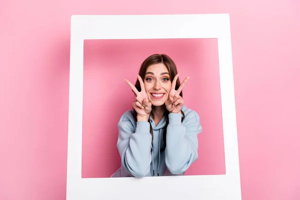 Photo of positive excited person hands fingers demonstrate v-sign isolated on pink color background.