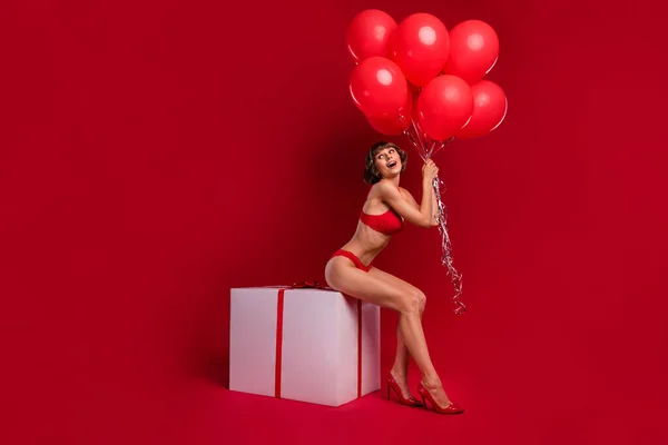 빨간색 배경에 고립된 상자에 매력적 아가씨의 몸길이 — 스톡 사진