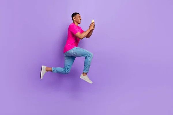 全长照片快乐兴奋的人跳着跑着用紫色背景隔离电话 — 图库照片