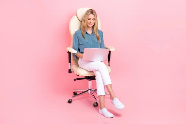 フルボディサイズ写真の若いですかなりブロンド髪素敵なビジネス女性ホールド新しいネットブックブラウジング情報座って椅子隔離されたピンク色の背景 — ストック写真