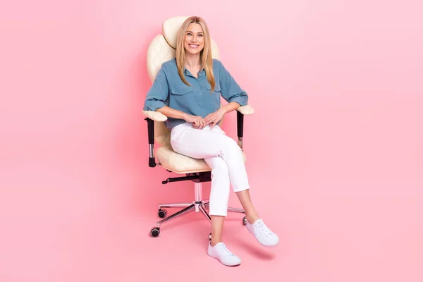フルボディサイズ成功した自信のある女性の写真新しいオフィスの上司の椅子かわいい笑顔リラックス一時停止明るいピンク色の背景に隔離された素敵な気分 — ストック写真