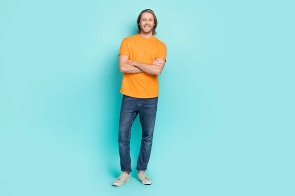 자신감 남자가 주황색 티셔츠를 고립된 청록색 배경을 가로지르는 — 스톡 사진