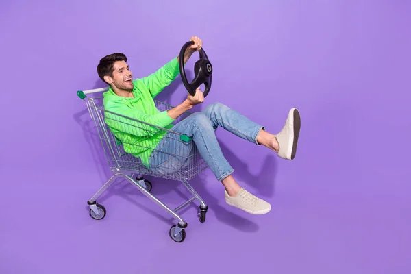 全长照片 漂亮时髦的男子身穿绿色连帽衫的超市托盘骑手驾驶汽车空旷的空间隔离紫色背景 — 图库照片