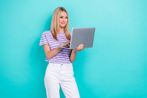 进步性女商人穿着时髦服装的照片拿着上网本打字 开发者在网上把它隔离在水蓝花的背景下 — 图库照片
