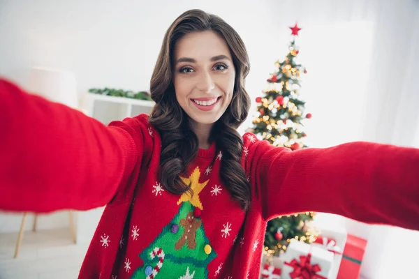 Photo of cheerful attractive pretty lady toothy smile make blog content share video new year cozy magic interior room house enjoy season.