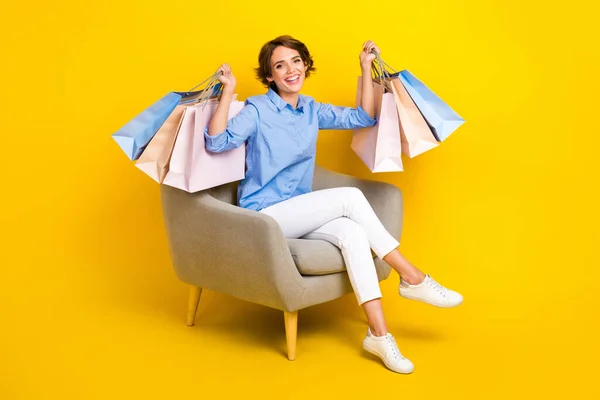 stock image Full length photo of funny cheerful lady wear blue shirt rising shoppers isolated yellow color background.