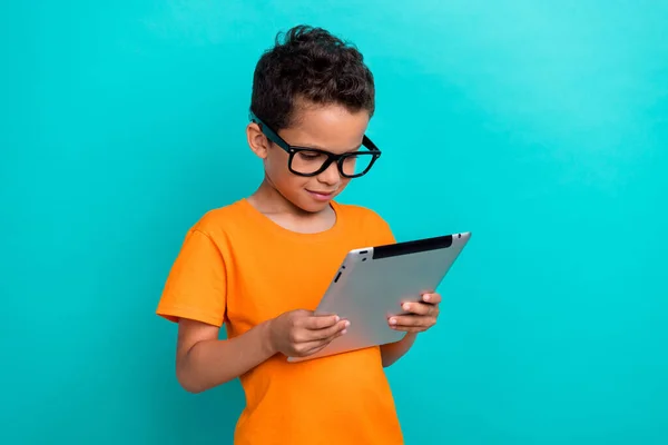 stock image Photo of clever funky little guy dressed orange t-shirt arm typing modern gadget empty space isolated teal color background.