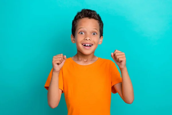 Foto Divertido Chico Afortunado Vestido Camiseta Naranja Sonriendo Puños Levantándose — Foto de Stock