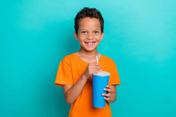 Stock image Photo of cute adorable little guy dressed orange t-shirt enjoying tasty drink isolated teal color background.