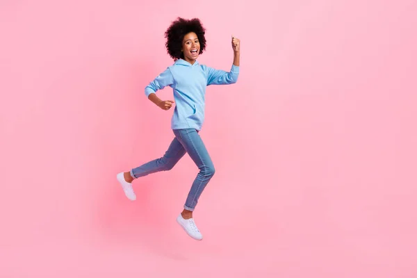 Full length profile portrait of delighted astonished person jumping raise fists isolated on pink color background.