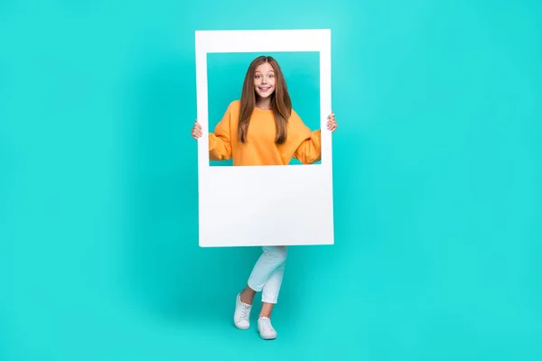 Tatlı Liseli Kızın Beyaz Fotoğraf Çerçevesi Taşıyan Turuncu Kazak Giydiği — Stok fotoğraf