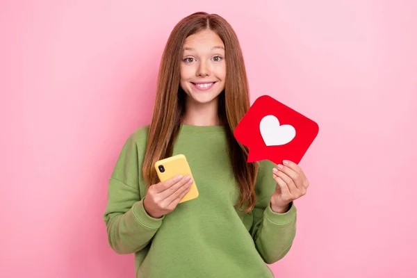 stock image Photo of cheerful positive optimistic girl with straight hairdo green sweater hold red like smartphone isolated on pink color background.