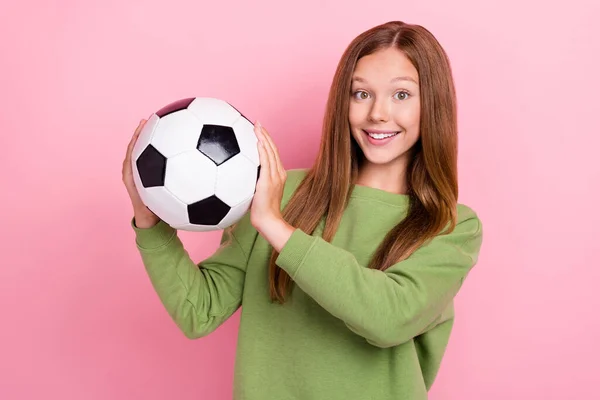 照片上兴奋的漂亮女生身穿绿色运动衫 足球上升 球体呈粉红色 背景孤立 — 图库照片