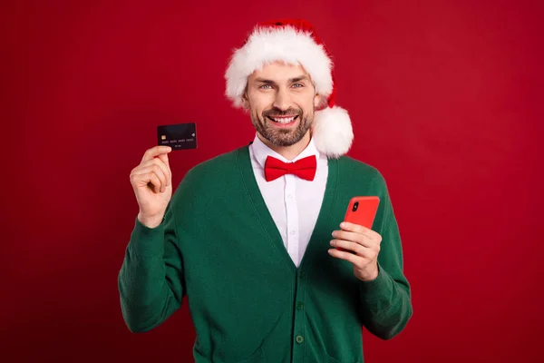 写真のハンサムな男の手を保持電話プラスチックデビットカードは 赤の色の背景に隔離 — ストック写真