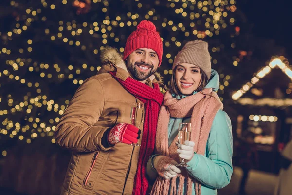 stock image Photo of two cheerful friendly people hands hold champagne glass december garland lights outside.