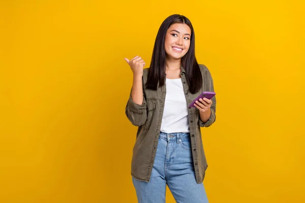 카키색 셔츠를 소녀의 모습노란 배경에 고립된 공간처럼 보이는 전화를 — 스톡 사진