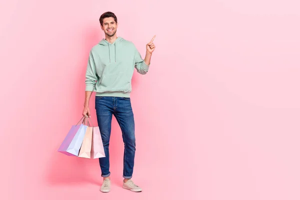 正の顧客の完全な長さの写真を着用カーキトレンディーな服を保持バッグアーム直接空のスペースピンク色の背景に隔離 — ストック写真