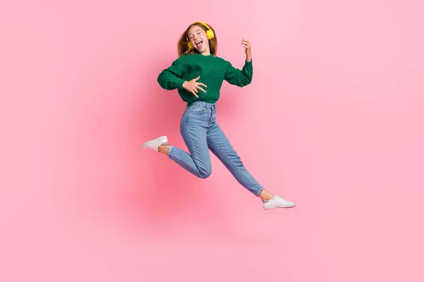 신나게 소녀의 Knitted Pullover 배경에서 점프를 즐기는 — 스톡 사진