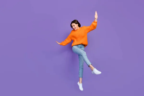 美しい若い女の子のダンスのフルボディ写真パーティー週末をお楽しみください服を着たスタイリッシュなオレンジ色のニットの外観紫色の背景に隔離された — ストック写真