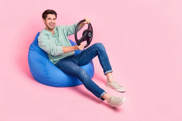 明るい男の完全な長さの写真座って椅子はスタイリッシュな服を身に着けているピンク色の背景に隔離された新しい高速車の空のスペースを喜ぶ — ストック写真