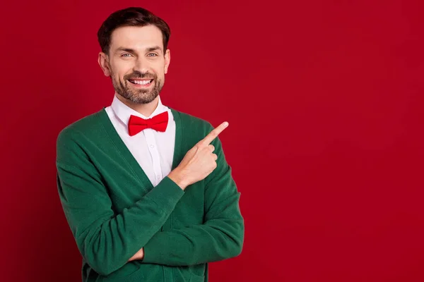 stock image Photo of smiling businessman wear green cardigan finger demonstrate new shopping mall offer cheap gifts for everyone isolated on red color background.