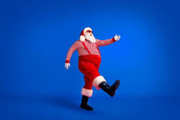 祖父灰胡子台阶的全长相貌提高了手穿圣诞老人服装吊带太阳镜条纹衬衫靴孤立的红色底色 — 图库照片